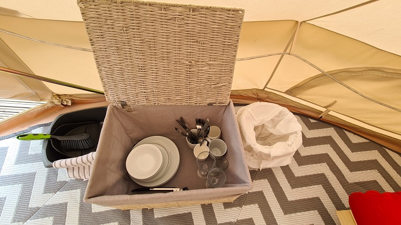 basket with cutlery and crockery provided for glamping